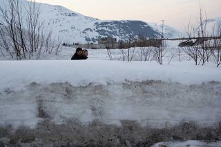 Люди идут по тротуару. Вид с дороги.